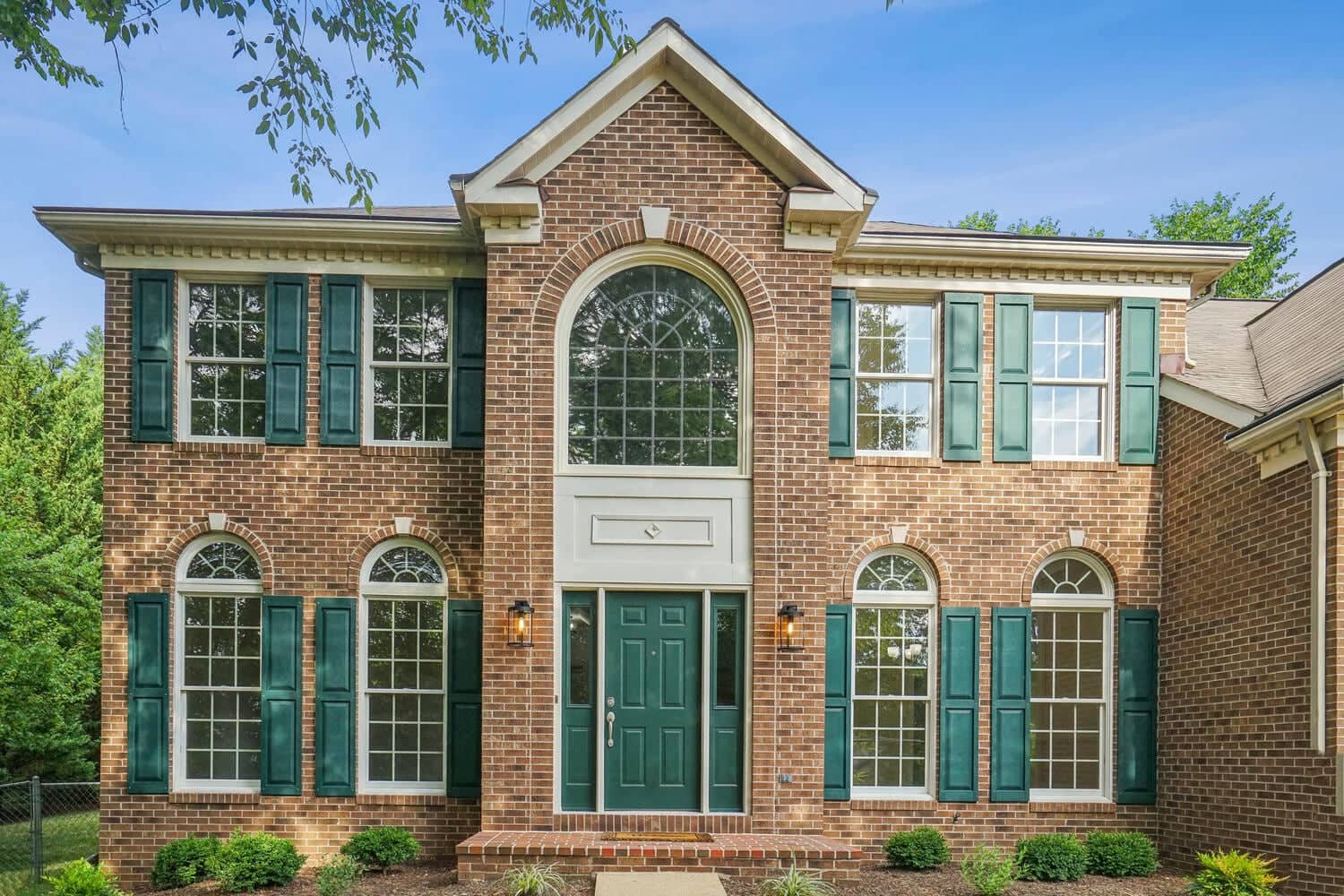 Front exterior of 4517 Forest Hill Drive showing the two-story brick Colonial facade and green shutters